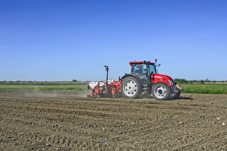 用拖拉机在他的田地上播种玉米.照片