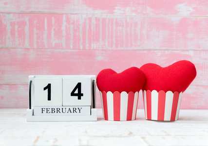 木历2月14日，两颗红色的心并排放置，背景是粉红色的。 情人节。