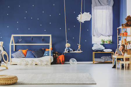 s room with Blue wall with golden stars and scandinavian wooden 