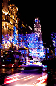 在马德里的街道上，夜晚充满了车辆和圣诞灯，包括在前线移动的汽车灯