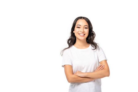 微笑的亚洲年轻女子，穿着白色T恤，双臂交叉，与白色隔离