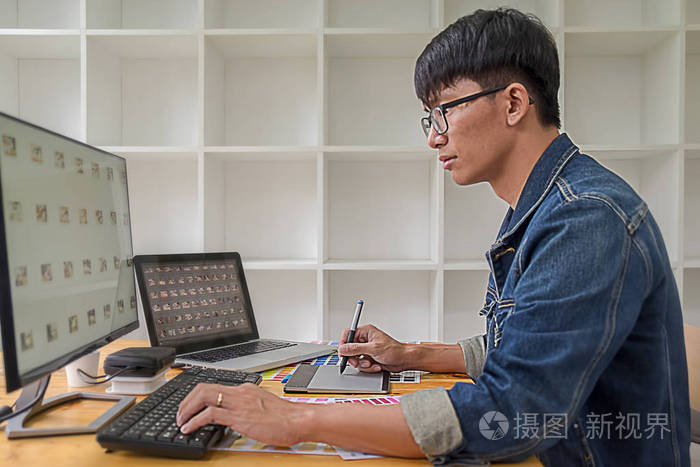 平面设计师用工作工具和附件在办公室的平板电脑上画一些东西.