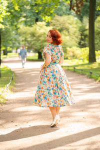 可爱的白种人女孩，红色鲍勃发型，复古服装，享受夏天阳光明媚的城市公园的生活