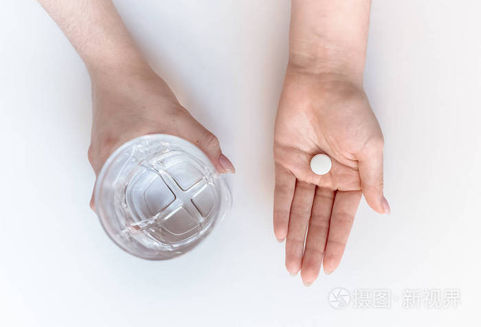 双手隔离在白色背景药丸和一杯止痛片上