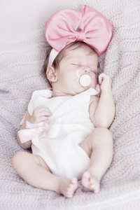 可爱的睡宝宝和粉红色的蝴蝶结。 新生儿。