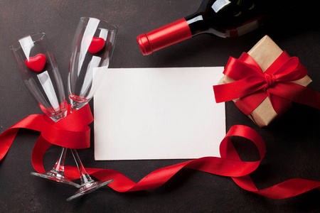 s day greeting card with red wine bottle and gift box on wooden 