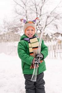 一个带冰柱的小男孩的冬天画像