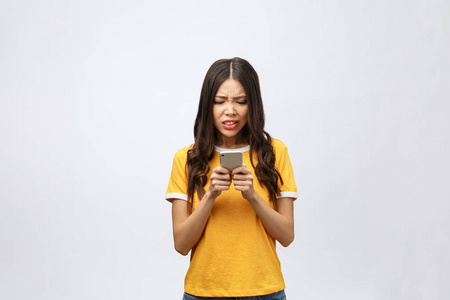 一个愤怒的亚洲妇女在手机讲话的肖像查出在白色背景