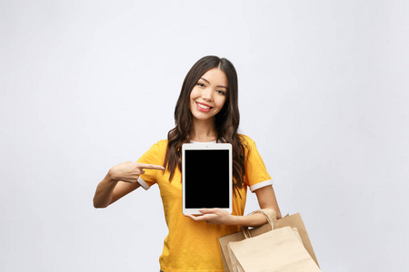 妇女的肖像在夏季礼服举行包袋与网上购物后购买, 使用平板电脑垫电脑隔离在白色的背景。复制广告空间