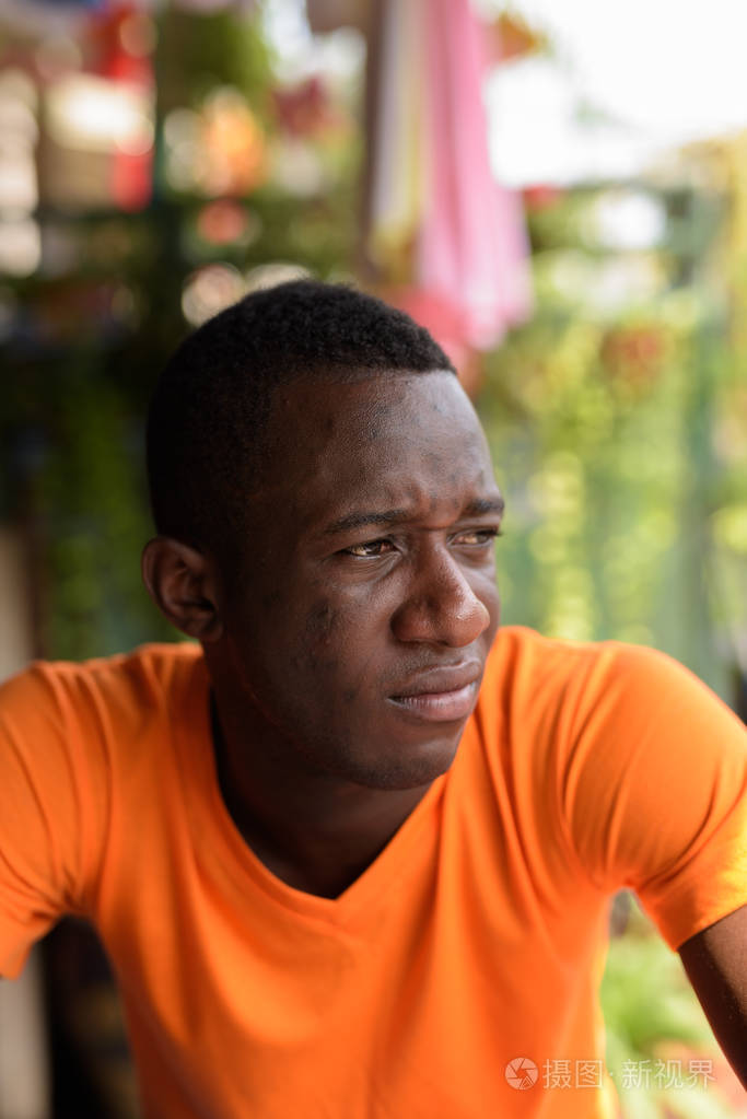 面对年轻的非洲黑人男子思考而看着不正常的