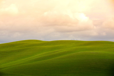 宁静的景观意大利托斯卡纳。 草地上的影子。 五颜六色的云。