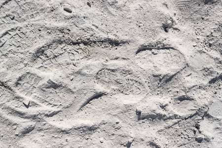 白沙或灰尘上的脚印。 人类在月球土壤或沙漠上的踪迹。