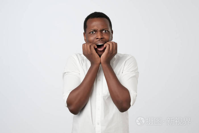 非洲男人用紧张的表情咬指甲面试前担心