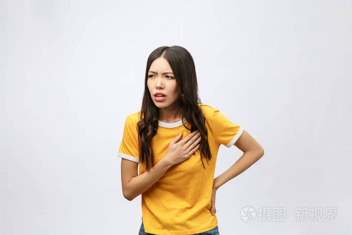 患有心脏病,疼痛,健康问题的妇女用隔离在灰色背景下的双手触摸胸部.