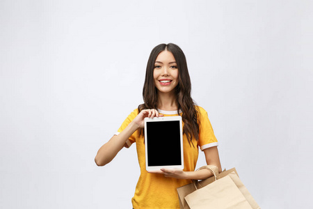 妇女的肖像在夏季礼服举行包袋与网上购物后购买, 使用平板电脑垫电脑隔离在白色的背景。复制广告空间