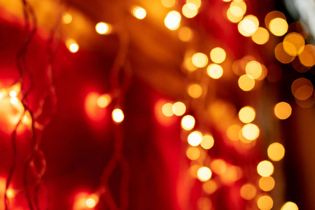 红色bokeh模糊灯光背景..黄金花环装饰为新年庆典。