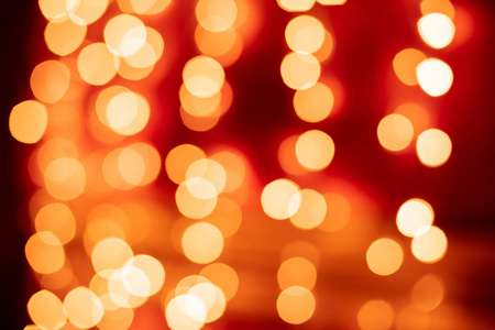 红色bokeh模糊灯光背景..黄金花环装饰为新年庆典。