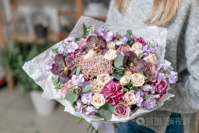 美丽的新鲜切花混合鲜花在女人的手.花店的花商的作品.