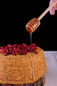 美味和非常美丽的蜂蜜蛋糕与酸奶油和浆果。 黑暗钥匙和蜂蜜蛋糕。