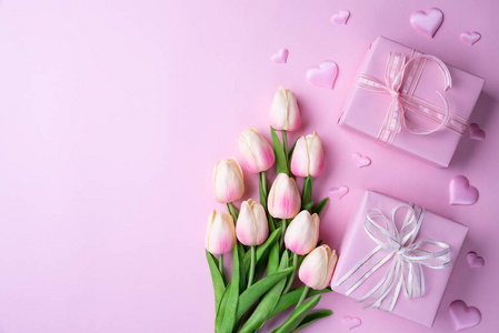 情人节和爱的概念。 粉红色郁金香礼盒，心在粉红色背景上。