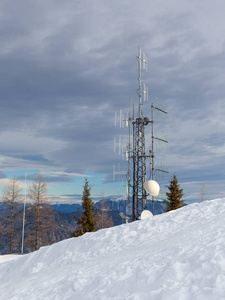 在冬季山景背景下安装天线和卫星天线的通信塔