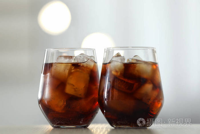 杯冰可乐放在桌子上背景模糊