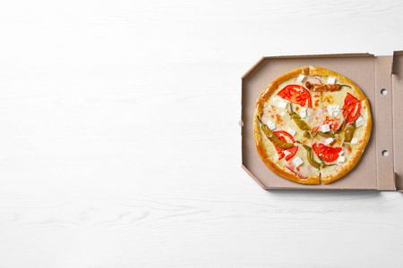 带有美味披萨的纸板箱，木制背景顶部视图，有文字空间