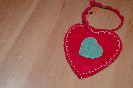 织物的心在木桌上, 上面有心形的绿色糖果