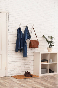 时尚的走廊内部，砖墙上有舒适的家具和衣服