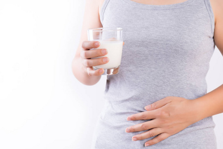 女人手拿着一杯牛奶，因为乳糖不耐受而胃痛。 乳制品保健和医疗理念的健康问题。