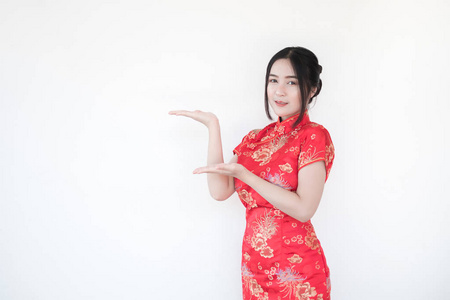 亚洲女性穿着传统的中国旗袍，白色背景上有一个欢迎的手势。女人举手建议事情。