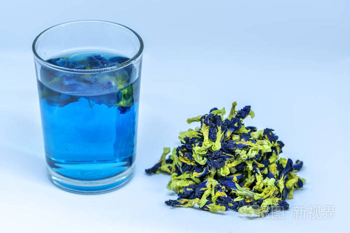 蝴蝶豌豆花干茶和杯子端成透明杯紫色模糊光空间背景蓝茶