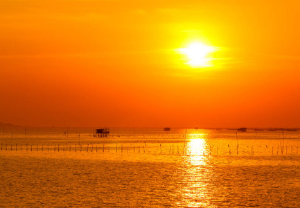 海滩上的日落，太阳从云层和海洋中反射出来。