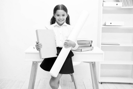 她喜欢创造性的工作。女孩的孩子持有文件夹和惠特曼纸, 而立场表白色内部。孩子学校制服愉快的面孔准备好与她的项目。小学生创意准备学