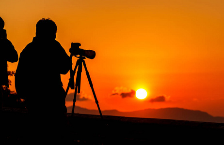 机的剪影图像,由摄影师和摄制组在专业起重机和三脚架上操作或拍摄