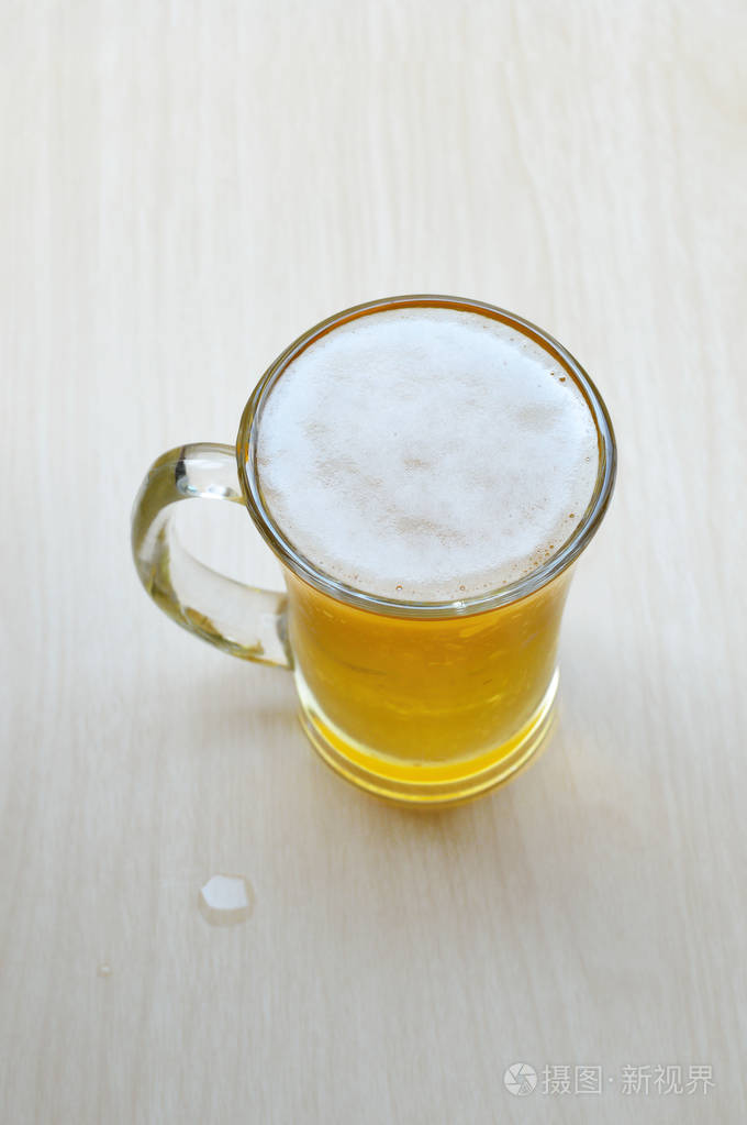 木桌上的一杯啤酒.
