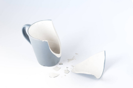 分离一个破碎的杯子。 破碎的杯子和碎片。 正面视图。