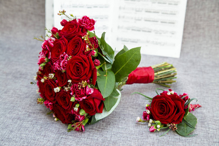 勃艮第玫瑰和康乃馨的新娘花束，以灰色背景为背景