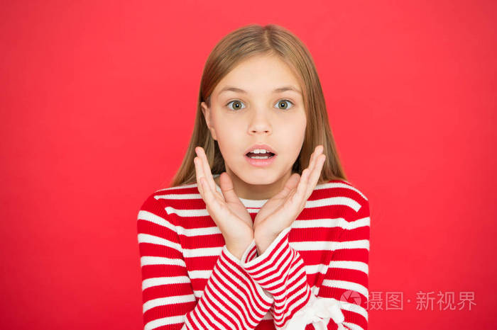 惊讶的小女孩在红色的背景.小女孩的孩子.学校教育.家庭和爱.儿童节.