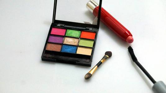 化妆和化妆品的工具，不同色调的眼影调色板和化妆刷的白色背景。 特写和选定的焦点。