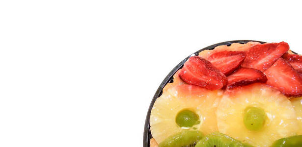 水果蛋糕与橙子，猕猴桃，葡萄，菠萝和草莓特写，隔离在白色背景上，并放置文字。 从上面看。