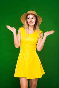 美丽的金发女郎在黄色的礼服和草帽
