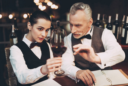 老经验的侍酒师告诉年轻女孩在餐厅红酒的味道的具体细节