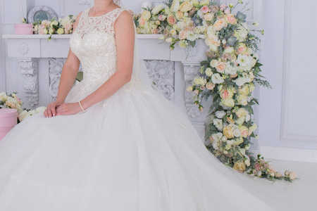 新娘在白色墙壁附近的面纱和花