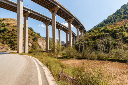 山上的一条柏油路经过中国的一座公路立交桥下