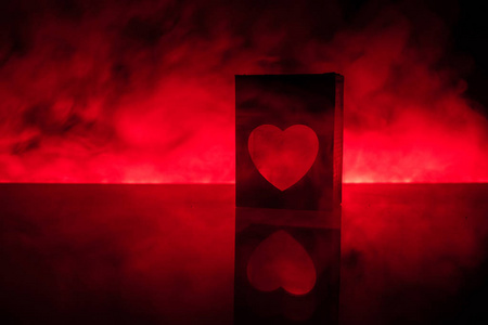 黑暗的桌面日概念和爱红色形状的心与bokeh背景空的文本和放置产品与复制空间。 模糊的发光的心在黑暗的背景上反射