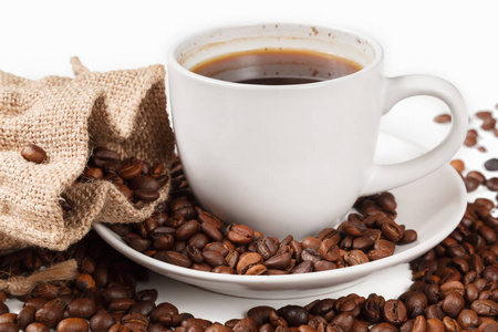 一杯浓咖啡在烤咖啡豆的白色背景隔离。
