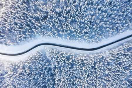 冬季时在道路和森林上鸟瞰..自然冬季景观从空中。森林下着雪是冬季.无人驾驶飞机的景观