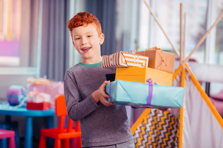 快乐的孩子展示他五颜六色的礼品盒
