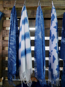 泰国诺塔布里市售的旅客，用围巾和披肩将蜡染与靛蓝挂在木墙上